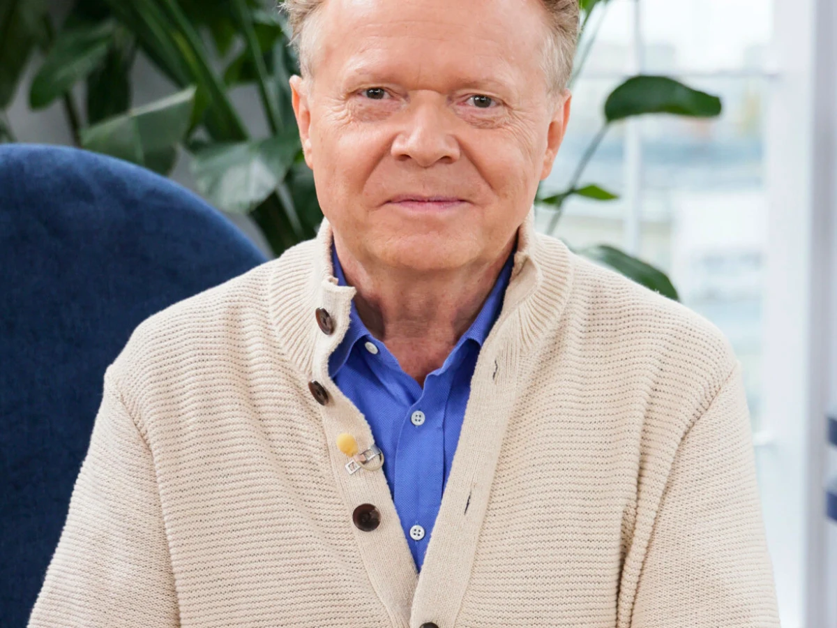 Michał Bajor Michał Bajor. Ma na sobie beżowy sweter oraz niebieską koszulę.