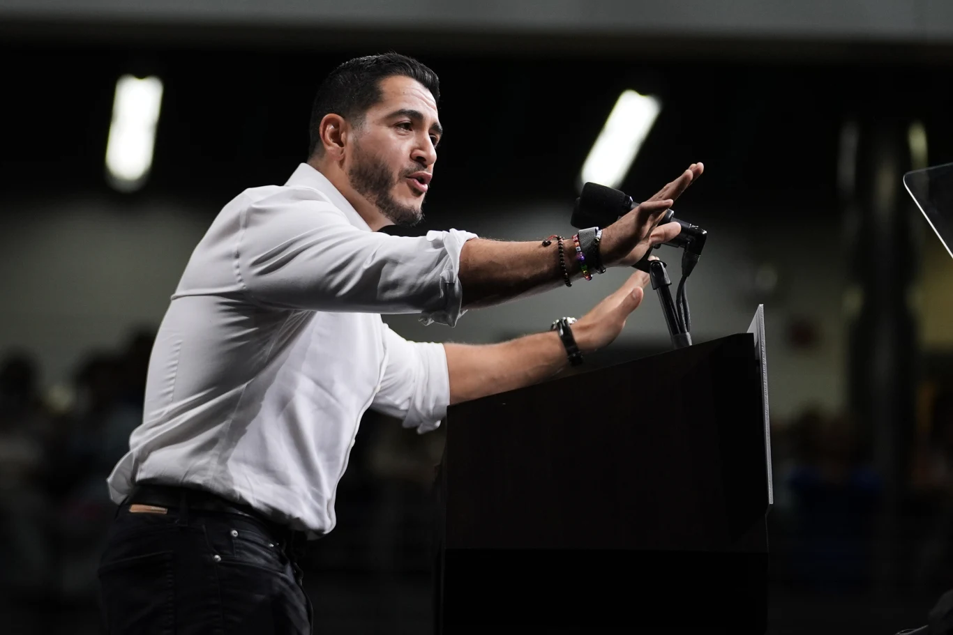 Abdul El-Sayed to centralna postać w gorącej batalii o mandat senacki z Michigan Mężczyzna w białej koszuli gestykulujący podczas przemówienia przy mównicy z mikrofonem.
