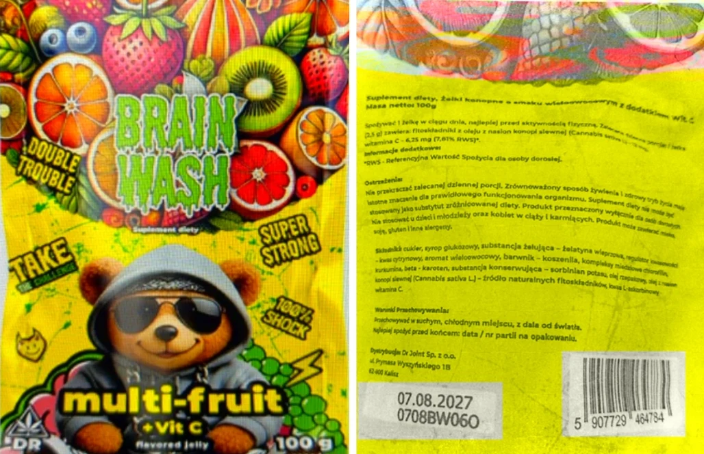 Kolorowe opakowanie żelek o smaku multi-fruit z hasłem 'Brain Wash', licznymi grafikami owoców oraz postacią misia w okularach przeciwsłonecznych na tle żółto-pomarańczowym, z wyróżnionymi napisami informującymi o zawartości witaminy C i dacie ważności.