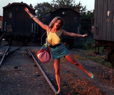 25 lat temu na ekrany polskich kin trafił film Radosława Piwowarskiego "Pociąg do Hollywood". Kreacja Marioli Wafelek - bufetowej z "Warsu", która marzy o hollywoodzkiej karierze, przyniosła nieznanej szerzej Katarzynie Figurze Złotą Kaczkę oraz tytuł seksbomby polskiego kina. Bohaterką "Pociągu do Hollywood" jest Mariola Wafelek (Katarzyna Figura), która - nazywana przez wszystkich Merlin - namiętnie pisze listy do słynnego reżysera Billy'ego Wildera. Na jedenaście listów nie otrzymała odpowiedzi, ale nie traci nadziei, że słynny reżyser kiedyś jednak powierzy jej rolę w swoim filmie. Przed laty jako mała dziewczynka, zamiast na lekcję religii, zbłądziła do remizy strażackiej na projekcję kina objazdowego dającego film "Pół żartem, pół serio".