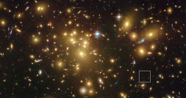 Abell 1689 w "obiektywie" teleskopu Hubble'a. Kwadratem zaznaczono ledwo widoczną A1689-zD1. /materiały prasowe
