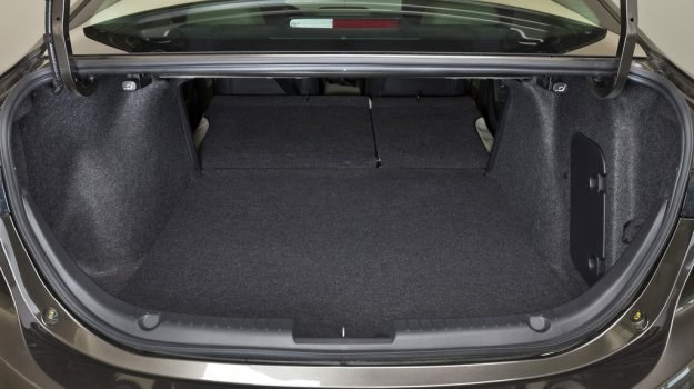 Aby złożyć oparcie kanapy w nowej Maździe 3 Sedan, wystarczy pociągnąć za dźwignię w bagażniku. /Mazda