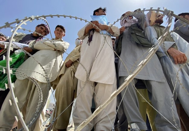 Afgańczycy, w tym ci, którzy pracowali dla USA, NATO, Unii Europejskiej i Organizacji Narodów Zjednoczonych w Afganistanie, czekają przed międzynarodowym lotniskiem na ucieczkę z kraju, po tym jak talibowie przejęli kontrolę nad Kabulem w Afganistanie.