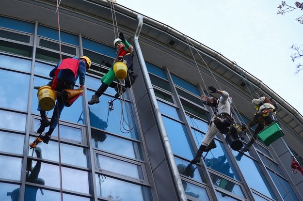 Akcja "Alpiniści dla WOŚP" w Krakowie (29.01). Pracownicy zaangażowanych firm z branży prac wysokościowych, przebrani za superbohaterów ze znanych animacji, w ramach pomocy dla USDK myją szpitalne okna zjeżdżając na linach z dachu budynków. /	Łukasz Gągulski /PAP