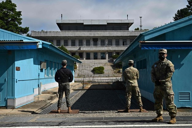 Amerykańscy żołnierze (po prawej) i wojskowy z Korei Południowej (po lewej) stojący przed wojskową linią demarkacyjną /ANTHONY WALLACE / AFP /East News