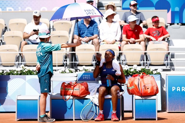 Amerykańska tenisistka Coco Gauff chroni się pod parasolem przed prażącym słońcem /RITCHIE B. TONGO /PAP/EPA