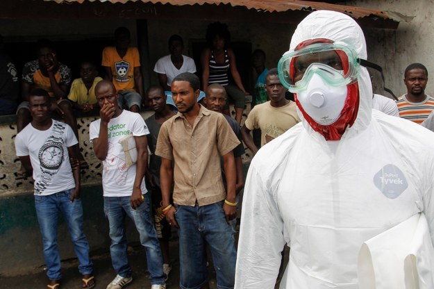 Amerykański operator kamery zaraził się ebolą w Liberii. Na zdjęciu: mieszkańcy i przedstawiciel służb medycznych na przedmieściach stolicy Liberii, Monrovii /AHMED JALLANZO  /PAP/EPA