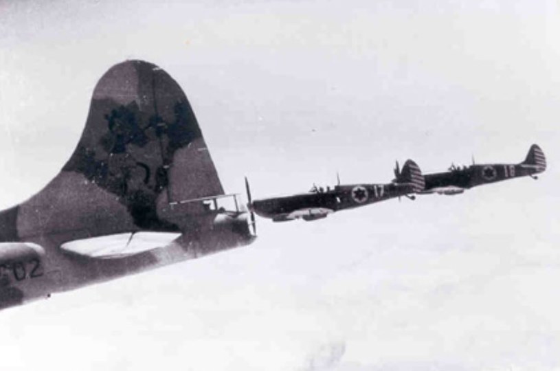 B-17 z namalowaną na stateczniku Myszką Miki, w eskorcie Spitfire Mk.IX podczas lotu bojowego nad Egiptem. Styczeń 1949 roku /domena publiczna