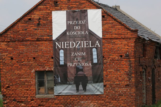 Baner 'Przyjdź do kościoła - niedziela - zanim cię przyniosą' w centrum wsi Sieroszewice /Tomasz Wojtasik /PAP