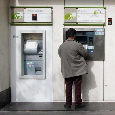 Banki zarabiają m.in. na wysokich prowizjach za wypłaty z obcych bankomatów. /AFP