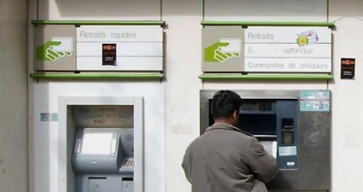 Banki zarabiają m.in. na wysokich prowizjach za wypłaty z obcych bankomatów. /AFP