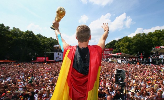 Bastian Schweinsteiger z Pucharem Świata podczas fety w Strefie Kibica w Berlinie /Fot. ALEX GRIMM/BONGARTS/GETTY IMAGES/DFB/DPA /PAP/EPA