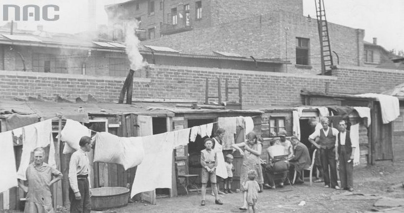 Bezrobotni mieszkańcy Królewskiej Huty przed swymi drewnianymi mieszkaniami /Z archiwum Narodowego Archiwum Cyfrowego