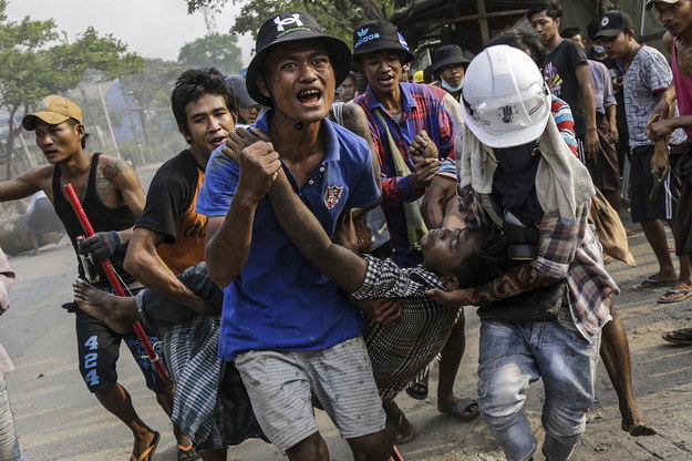 Birmańczycy przenoszący rannego demonstranta, aby udzielić mu pomocy /STRINGER /PAP/EPA