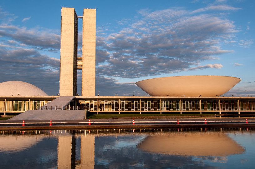 Brazylijski Kongres Narodowy, którego zarys odbija się w wodzie przy zachodzącym słońcu. /123RF/PICSEL