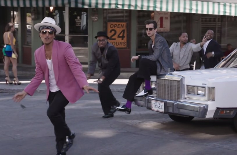 Bruno Mars (z przodu) i Mark Ronson (siedzacy na samochodzie) w klipe "Uptown Funk" /