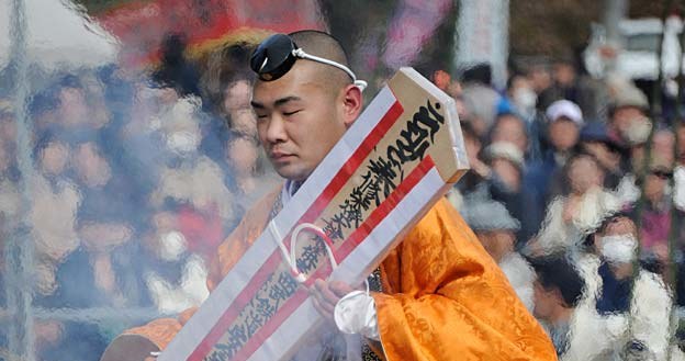 Buddyjski mnich, z talizmanem w rękach, przechodzi gołymi stopami po rozżarzonych węglach, Japonia /AFP