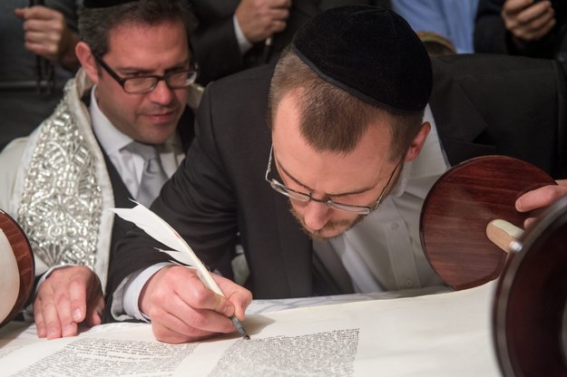 Chazan Avromi Freilich (L) z Hampstead Garden Suburb Synagogue i łódzki rabin pomocniczy Dawid Szychowski (P) dopisuje jeden z ostatnich znaków w nowym zwoju Tory ofiarowanej Gminie Wyznaniowej Żydowskiej w Łodzi / 	Grzegorz Michałowski    /PAP/EPA