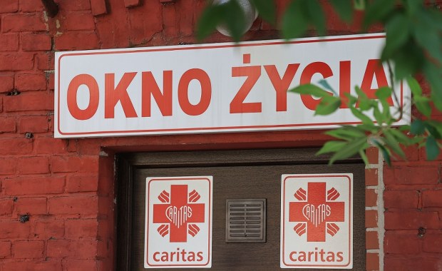 Chłopiec w oknie życia w Świdnicy. Przy dziecku karteczka 