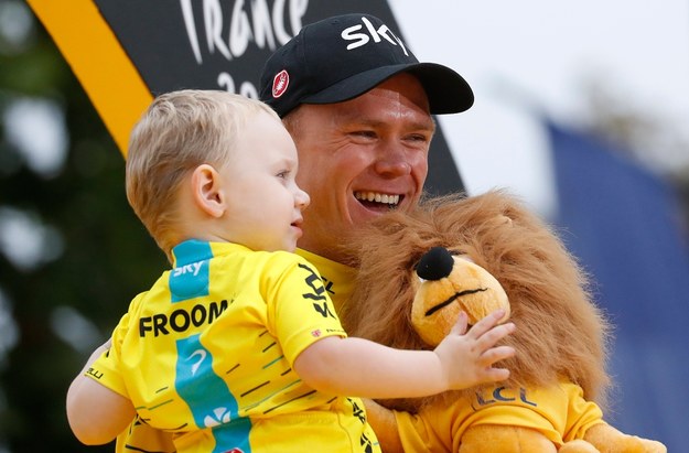 Chris Froome z ekipy Sky po raz czwarty wygrał największy wyścig kolarski Tour de France. Na zdjęciu ze swoim dzieckiem. /GUILLAUME HORCAJUELO  /PAP/EPA