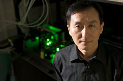Chunlei Guo na tle lasera, który wykorzystuje do modyfikowania powierzchni &nbsp; /University of Rochester