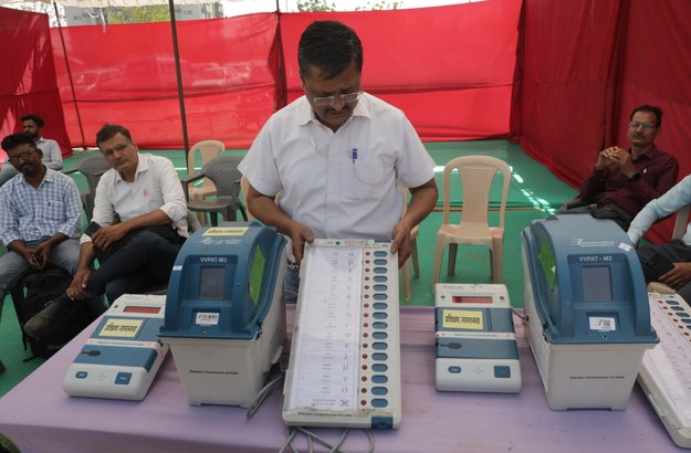Członek komisji wyborczej demonstruje działanie maszyny do głosowania w lokalu wyborczym w Jaipur w północno-zachodnich Indiach. /RAJAT GUPTA    /PAP/EPA