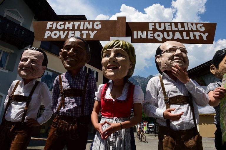 Członkowie organizacji Oxfam w tradycyjnych bawarskich strojach z maskami uczestników G7 /JOHN MACDOUGALL /AFP