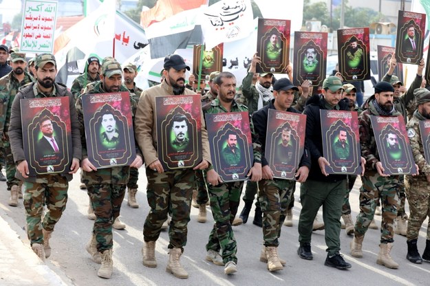 Członkowie Sił Mobilizacji Ludowej maszerujący z wizerunkami osób, które miały zginąć w ataku /AHMED JALIL /PAP/EPA