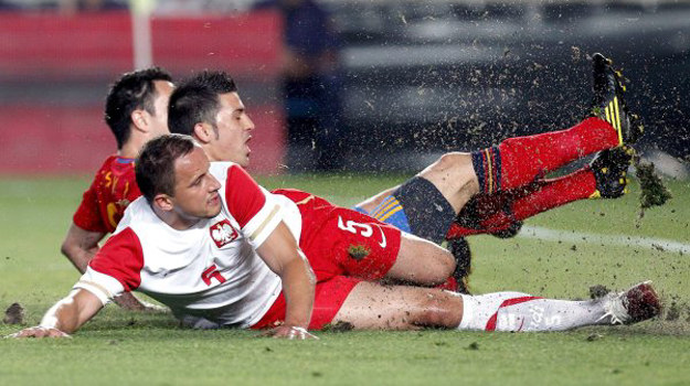 Dariusz Dudka nieudolnie walczy o piłkę. Tak padła pierwsza z sześciu bramek dla Hiszpanów /AFP