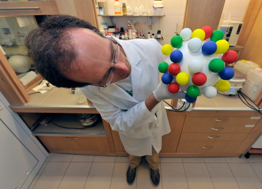 Dr inż. Rafał Szmigielski z IChF PAN prezentuje poglądowy model drobiny pyłu zawieszonego /IChF PAN, Grzegorz Krzyżewski /materiały prasowe