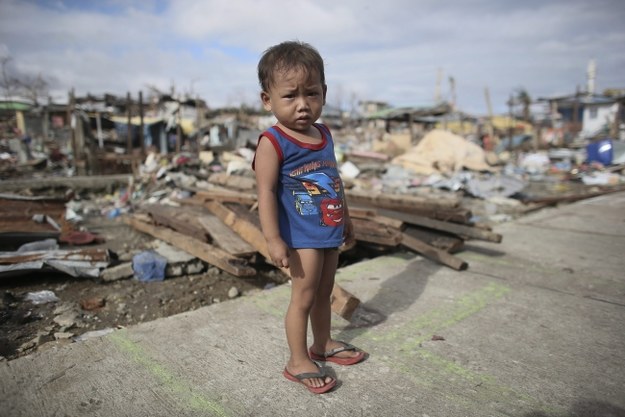 Dwuletni chłopiec pozujący na tle ruin miasta Tacloban /NIC BOTHMA /PAP/EPA