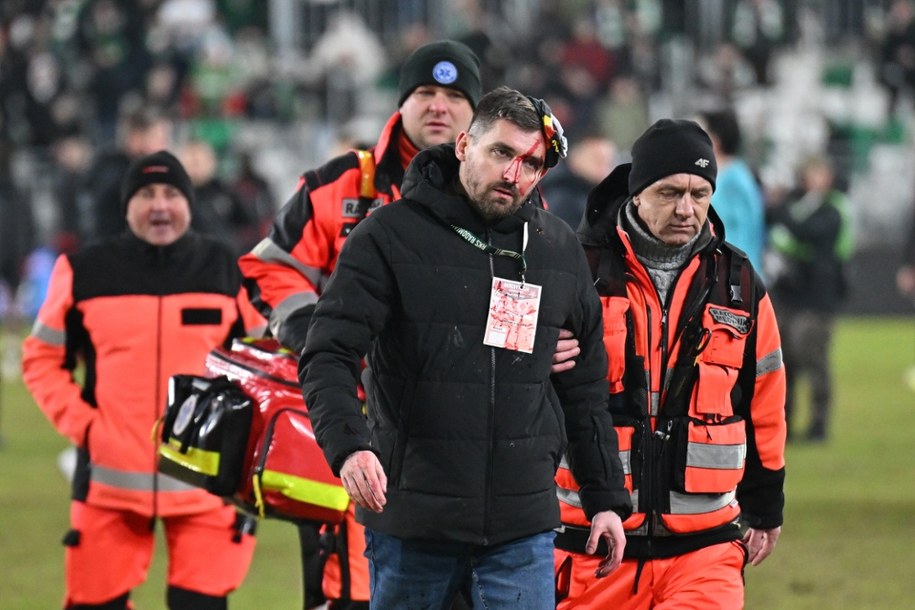 Dyrektor komunikacji i marketingu Korony Kielce Michał Siejak z rozciętą głową wyprowadzany przez ratowników medycznych po meczu 21. kolejki piłkarskiej Ekstraklasy z Radomiakiem Radom /Piotr Polak /PAP