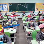 Dzieci w Chinach noszą czapeczki pomagające zachować dystans