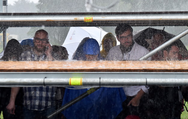 Dziennikarze chowają się przed deszczem na lotnisku Balice /Radek Pietruszka /PAP