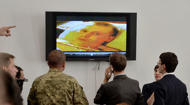 Dziennikarze i ukraińscy wojskowi oglądają wideo z ujętym rosyjskim żołnierzem fot. Genya Savilov /AFP