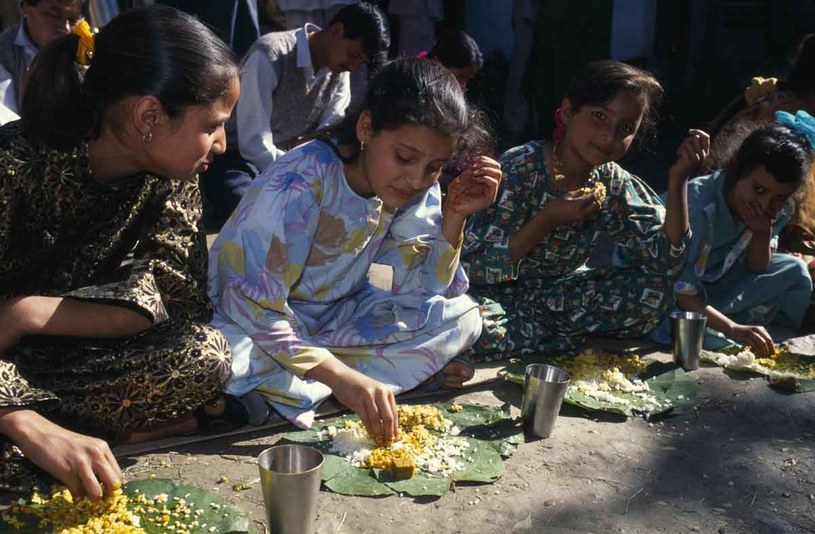 Dziewczęta jedzą posiłek z lisci bananowca podczas wiejskiego wesela w Kulu /Getty Images