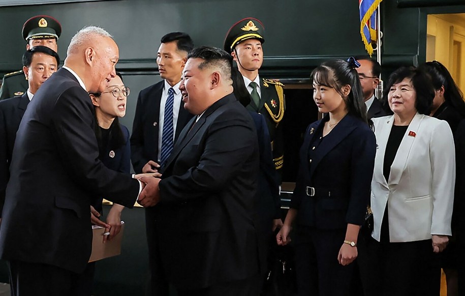 Dziewczynka, którą prawdopodobnie uważa się za córkę Kim Dzong Una, stoi za północnokoreańskim przywódcą na zdjęciu udostępnionym przez rząd Korei Północnej we wtorek, 2 września 2025 r. fot. AFP PHOTO/KCNA VIA KNS /East News