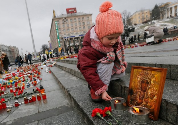 Dziewczynka zapala znicz w hołdzie ofiarom ostrzału Mariupola /SERGEY DOLZHENKO /PAP/EPA