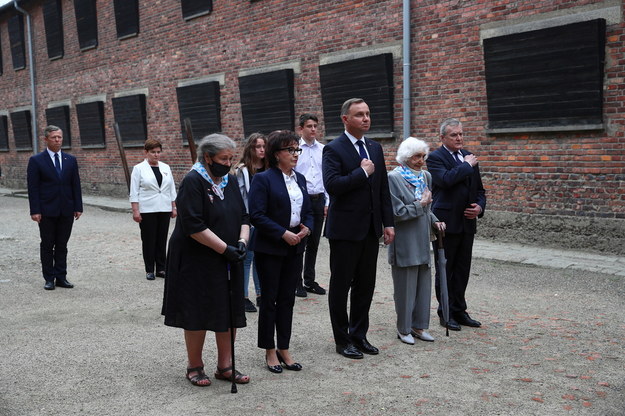 Europoseł PiS Beata Szydło (2L), wojewoda małopolski Piotr Ćwik (L), byłe więźniarki obozu Barbara Wojnarowska-Gautier (3L) i Lucyna Adamkiewicz (2P), wicepremier, minister kultury i dziedzictwa narodowego Piotr Gliński (P), prezydent Andrzej Duda (3P) oraz marszałek Sejmu Elżbieta Witek (4L) składają wieńce pod Ścianą Straceń na dziedzińcu bloku 11 w byłym obozie Auschwitz I