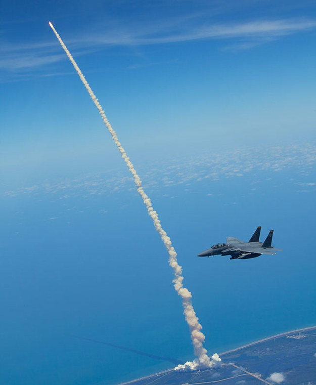 F-15E Strike Eagle na tle startującego promu kosmicznego Atlantis &nbsp; /Fot. U.S. Air Force photo/Capt. John Peltier