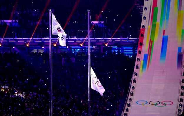 Flaga olimpijska jest podciągana na maszcie. /Daniel Kopatsch /PAP/EPA