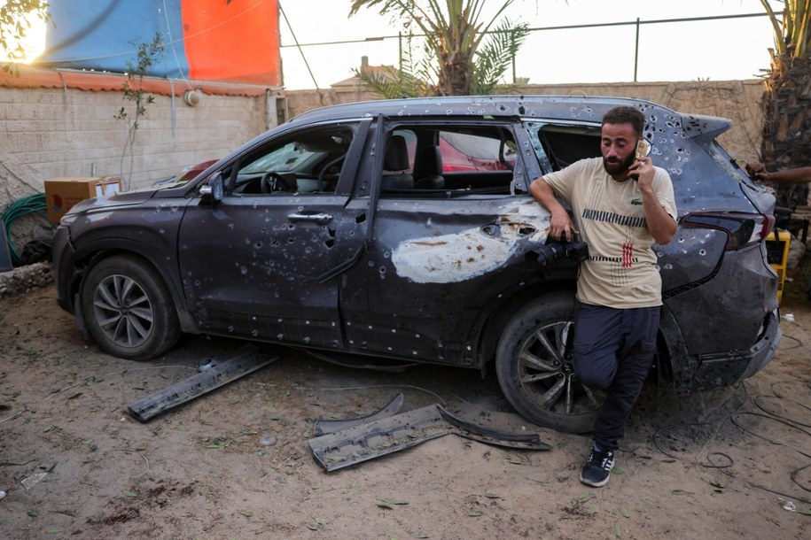 Fotoreporter obok uszkodzonego pojazdu po izraelskim ataku w centralnej Gazie /BASHAR TALEB / AFP /East News