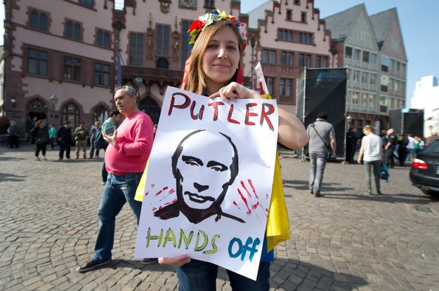 Frankfurt nad Menem. Uczestniczka demonstracji przeciw aneksji Krymu trzyma transparent z napisem: "Putler ręce precz" /BORIS ROESSLER   /PAP/EPA