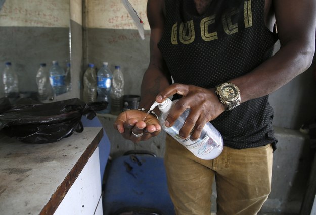 Fryzjer dezynfekujący dłonie przed obsługą klienta. Wybrzeże Kości Słoniowej /LEGNAN KOULA /PAP/EPA