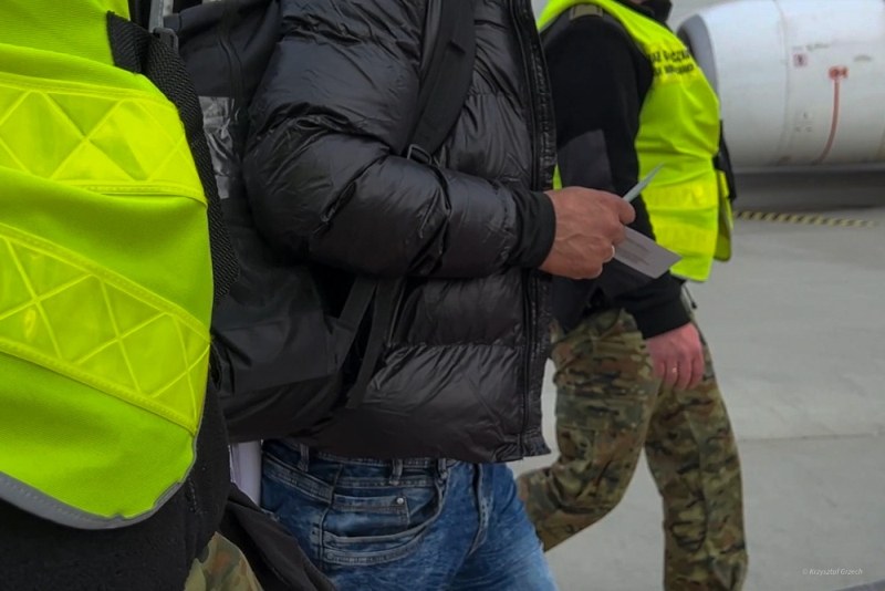 Funkcjonariusze SG prowadzą osobę deportowaną z Polski /Straż Graniczna