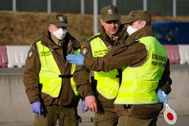 Funkcjonariusze służb granicznych podczas kontroli sanitarnej pasażerów autobusów wjeżdżających do Polski / 	Andrzej Grygiel    /PAP