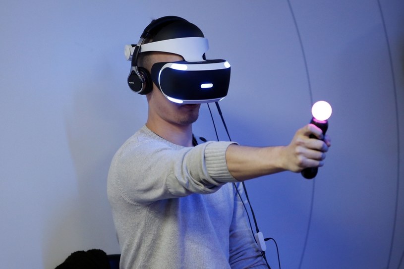 Gogle PlayStation VR to przepustka do wirtualnego świata. W dłoni widać PlayStation Move - kontroler ruchowy, którym symuluje np. pistolet w świecie wirtualnym /AFP