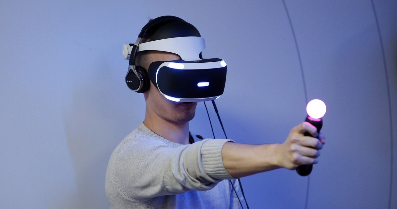 Gogle PlayStation VR to przepustka do wirtualnego świata. W dłoni widać PlayStation Move - kontroler ruchowy, którym symuluje np. pistolet w świecie wirtualnym /AFP