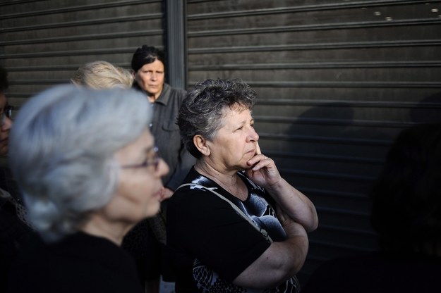 Greccy emeryci, którzy nie posiadają kart do bankomatów, czekają w kolejce przed bankiem w Peristeri pod Atenami, by wypłacić pieniądze z kont. Pozostali Grecy mogą korzystać wyłącznie z bankomatów /FOTIS PLEGAS G. /PAP/EPA