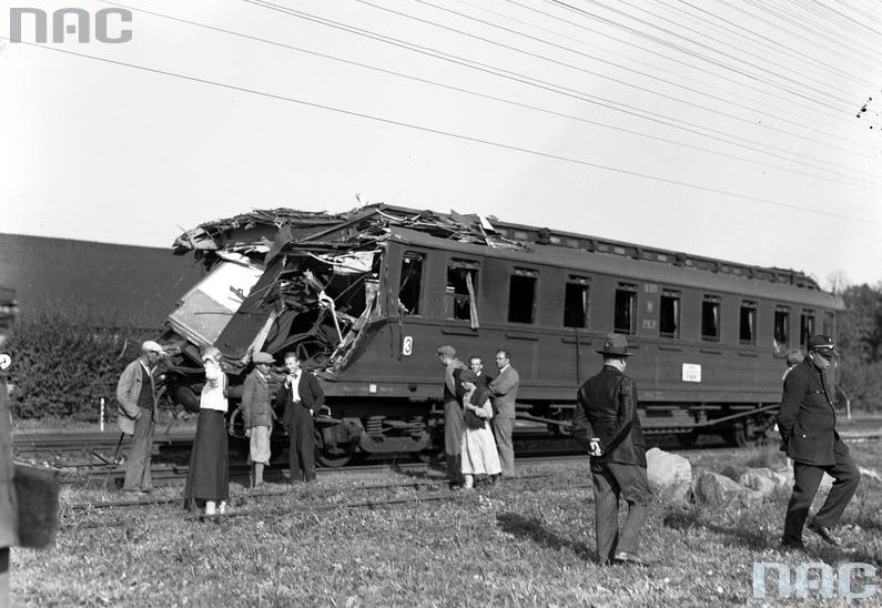 Grupa ludzi przy zniszczonym wagonie /Z archiwum Narodowego Archiwum Cyfrowego